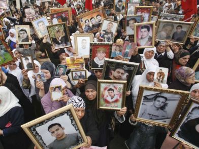 Palestinian women hold pictures of jailed relatives during a protest marking 